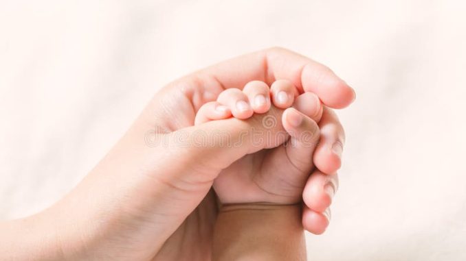 mano-del-bebé-que-detiene-la-mamá-del-finger-en-tono-del-vintage-76877037